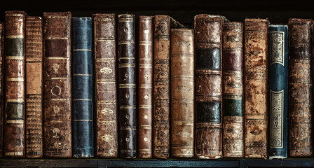 Old books on wooden shelf. Tiled Bookshelf background.  Concept on the theme of history, nostalgia,...