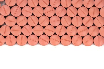 Orange colour round pills on white  background with selective focus. Pills that look like ecstasy
