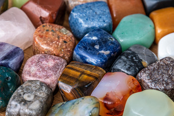 Collection of different colored polished gemstones an jewels pure luxury on wooden underground