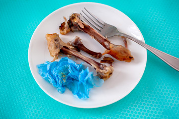 Plate with eaten chicken leg bones