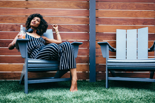 Woman relaxing in chair on artificial grass