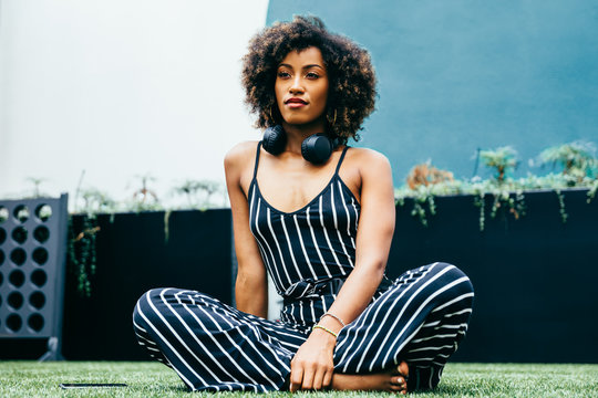 Low Angle View Of Woman Sitting Cross-legged On Grass