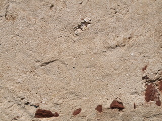Old Stucco Wall with Bits of Red Rock Exposed