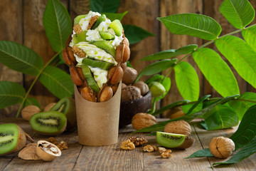 Hong Kong bubble waffles stuffed with whipped cream and kiwi fruit slices and walnut. Branches and...