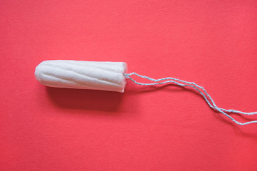 new swab on a red background. gynecological banner with tampon and  place for text