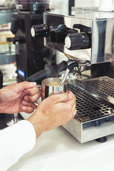 Coffee machine and barista preparing coffee in a cafe shop