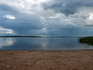 Beautiful, peaceful lake shore with storm clouds, wonderful reflections, Lake Burtnieks, Latvia