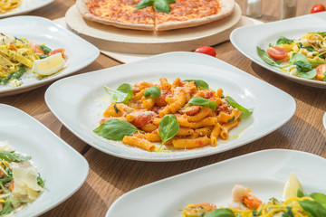 Set of fresh served pasta dishes and pizza. Italian food background