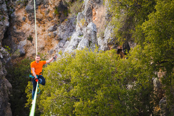 A man sits on a stretched sling.
