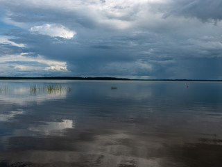 Storm clouds rolling in over peaceful lake,wonderful reflections, Lake Burtnieks, Latvia