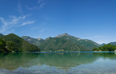 Fototapeta na wymiar Mountain reflections in the water of Lago Di Ledro. Trento, Italy