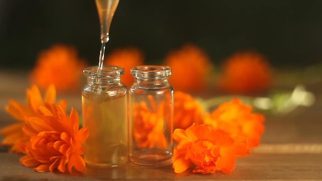 Essence of calendula flowers on table in beautiful glass bottle