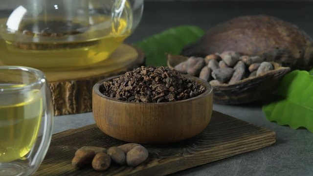 Hot Cacao Tea. Fresh hot chocolate herbal tea made of cacao bean flakes, which is rich in flavonoids and antioxidants, served in glasses, Selective Focus dark background.