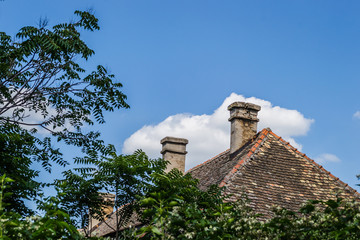 Old dilapidated brick chimney on the roof of the house