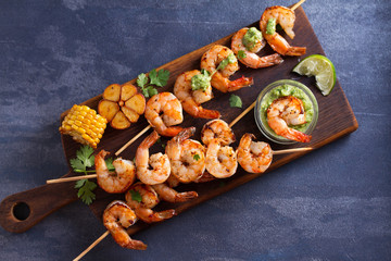 Cilantro lime grilled shrimps. Shrimps on skewers with garlic butter sauce. View from above, top studio shot