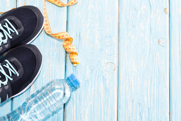 sneakers water bottle on light blue wooden background.