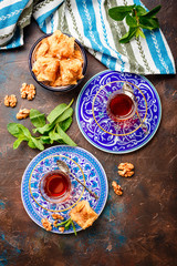 Traditional Turkish arabic dessert and a glass of tea with mint