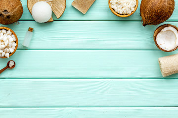 Homemade organic cosmetics with coconut on mint green wooden background top view mock up