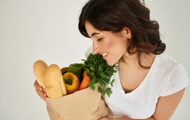 young woman holding shopping bag full of groceries