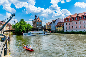 Bamberg at the old harbor with excursion boat and paddle boat in the background the old town hall