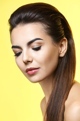 Naklejka premium Young woman with beautiful eyebrows on color background