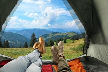 Fotobehang Closeup of people in camping tent with sleeping bags on mountain hill, view from inside © New Africa