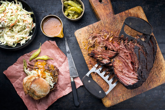 Traditional barbecue wagyu pulled beef with coleslaw  as closeup on a rustic cutting board