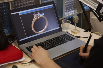 Obraz na płótnie Canvas Jewelry designer working on laptop, closeup