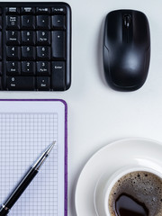 Office table desk. Workspace with blank note book, keyboard, office supplies and coffee cup on...