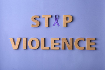 Fototapeta na wymiar Flat lay composition with purple ribbon and words STOP VIOLENCE on violet background. Awareness day