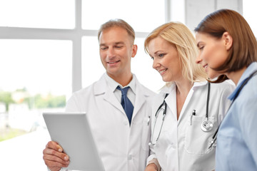 healthcare, medicine and technology concept - group of doctors with tablet computer at hospital