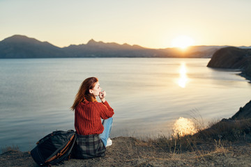 woman sitting on a rock and looking at the sea