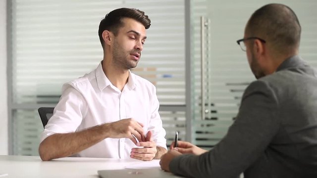 Male salesman talking with client handshaking closing deal at meeting