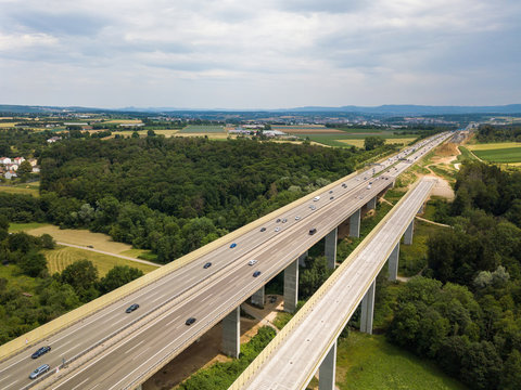 Aerial view of a German Autobahn with construction works for a new railway bridge next to it. Drone photo taken at Denkendorf near Stuttgart - on a weekend, hence not much truck traffic.