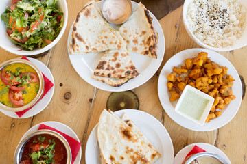 food, south asian cuisine, culinary and cooking concept - various dishes on table of indian restaurant