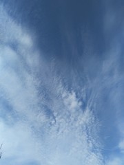 shaggy haze of white clouds smeared across blue sky, natural background