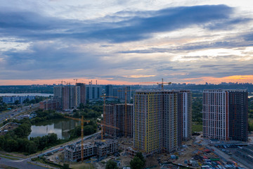 Background of silhouette building crane lift loads with sun set rays yellow cloudy evening sky backdrop Construction site at orange sunset