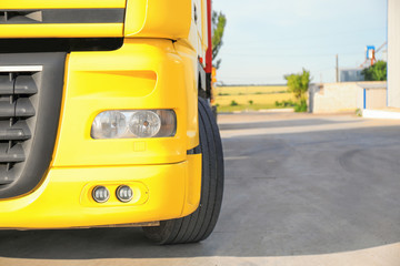 Modern yellow truck on road, closeup. Space for text