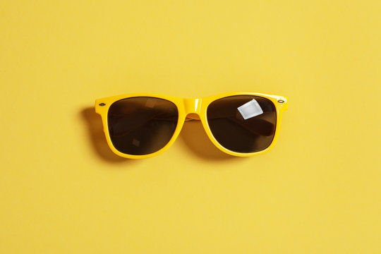 Stylish sunglasses on color background, top view. Beach accessories