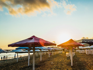 Beach umbrellas on the beach in the evening at sunset.