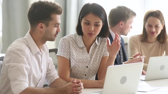 Female asian mentor teaching male caucasian intern explaining online strategy