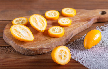 sliced kumquats on a wooden kitchen board