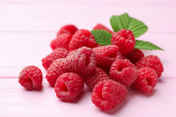 Delicious fresh ripe raspberries on pink wooden table, closeup view