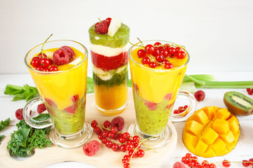 Kolorowe warstwowe smoothie z mango, kiwi, selera naciowego, malin, porzeczek, banana, jarmużu i kremu waniliowego