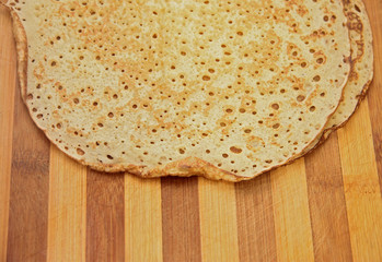Stack of homemade pancakes on wood cooking board