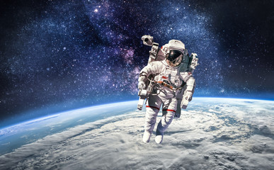 Astronaut in the outer space over the planet Earth. Abstract wallpaper. Spaceman. Elements of this image furnished by NASA - obrazy, fototapety, plakaty