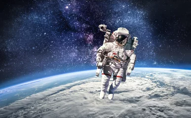 Selbstklebende Fototapeten Astronaut im Weltraum über dem Planeten Erde. Abstrakte Tapete. Raumfahrer. Elemente dieses von der NASA bereitgestellten Bildes © dimazel