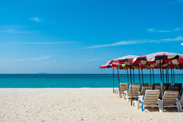 Beach chairs on sand beach with blue sky