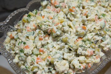 Mayonnaise salad. Food background - salad olivier close-up. Green peas, cucumber, potatoes, sausage, mayonnaise . Azerbaijani capital salad.On the plate capital salad.
