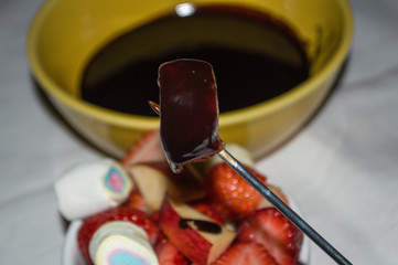 sweet chocolate fondue and ramekin pot with red fruits (apple and strawberry) and marshmallow